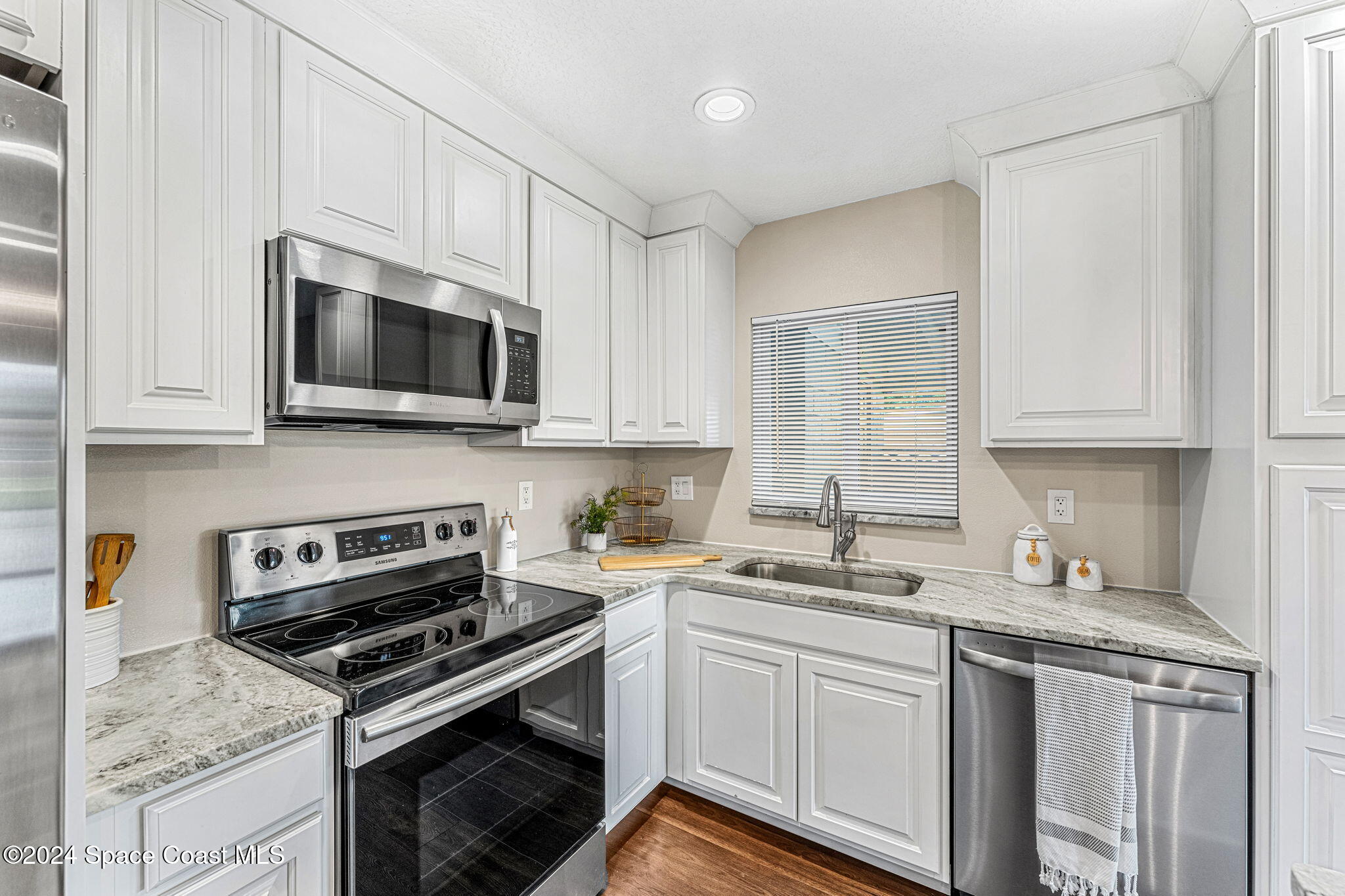 5120 Sutton Avenue Melbourne, FL 32904 - Photo 8 of 38 a kitchen with cabinets stainless steel appliances a sink and a counter space