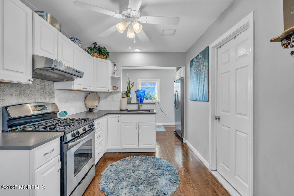 19 Gravelly Point Road Highlands, NJ 07732 - Photo 14 of 44 a kitchen with stainless steel appliances granite countertop a sink a stove a refrigerator cabinets and a window