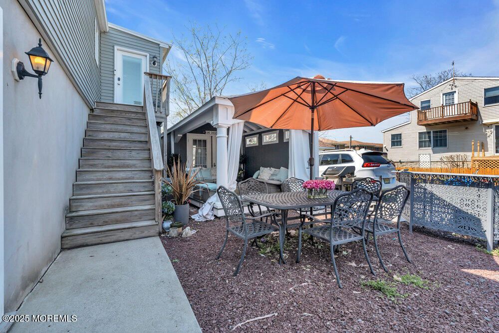 19 Gravelly Point Road Highlands, NJ 07732 - Photo 37 of 44 a view of a tables and chairs under an umbrella in the patio