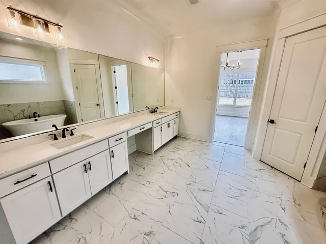 a large bathroom with a double vanity sink a mirror and a bathtub