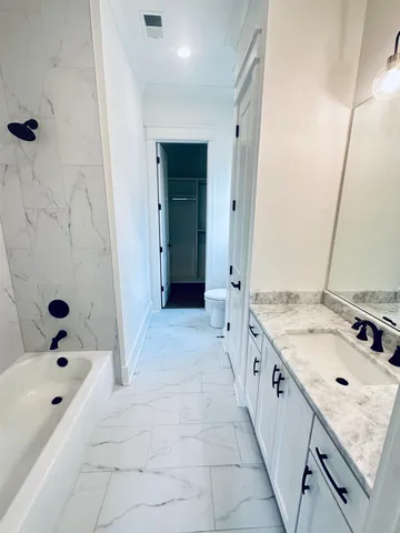 a bathroom with a tub sink and mirror