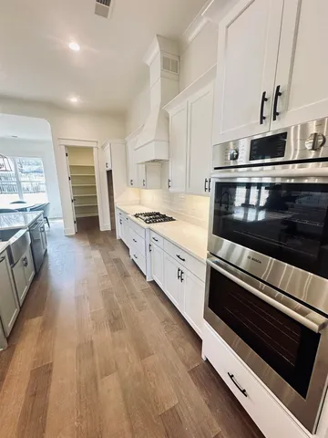 a kitchen with stainless steel appliances and white cabinets