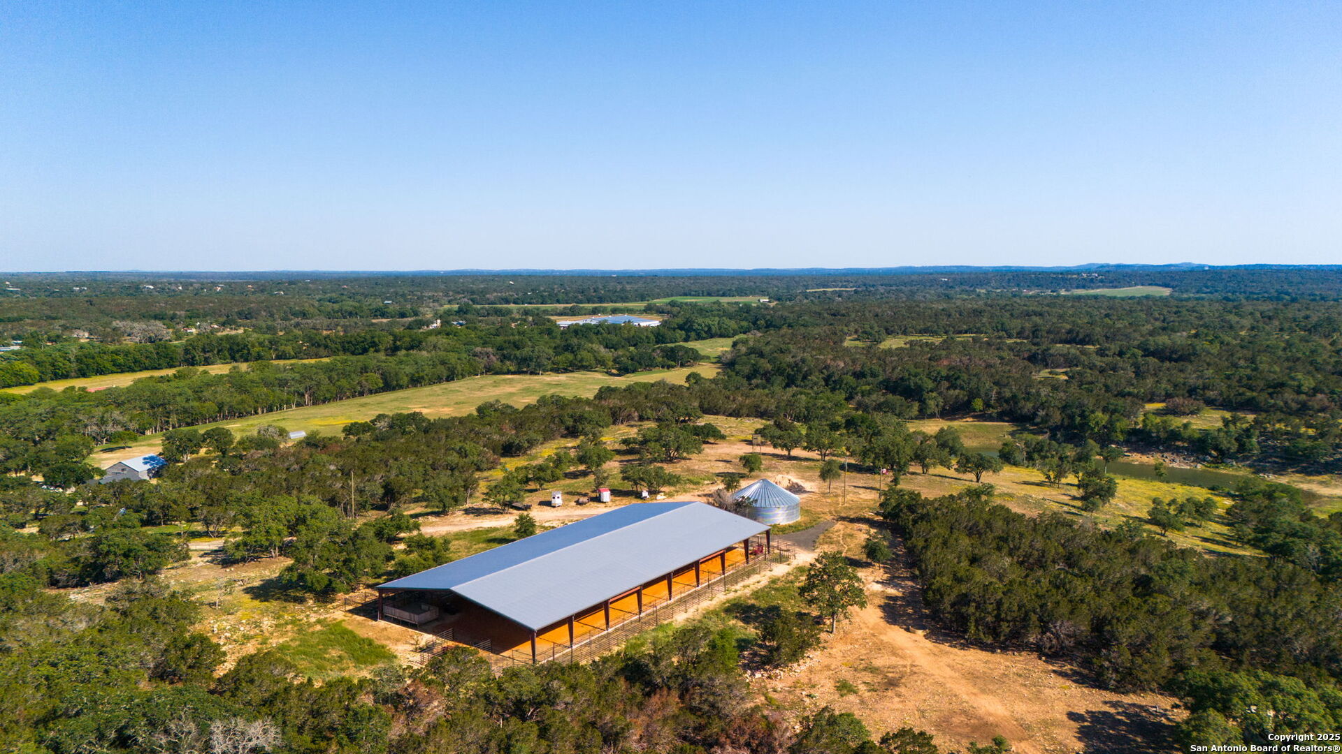an aerial view of residential houses with outdoor space and trees
