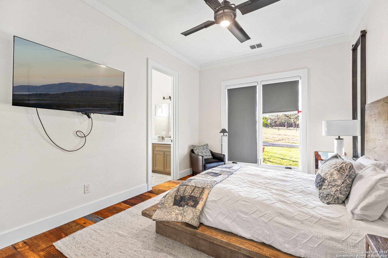 1146 Sisterdale Road Boerne, TX 78006 - Photo 16 of 94 a bedroom with a bed and a painting on the wall