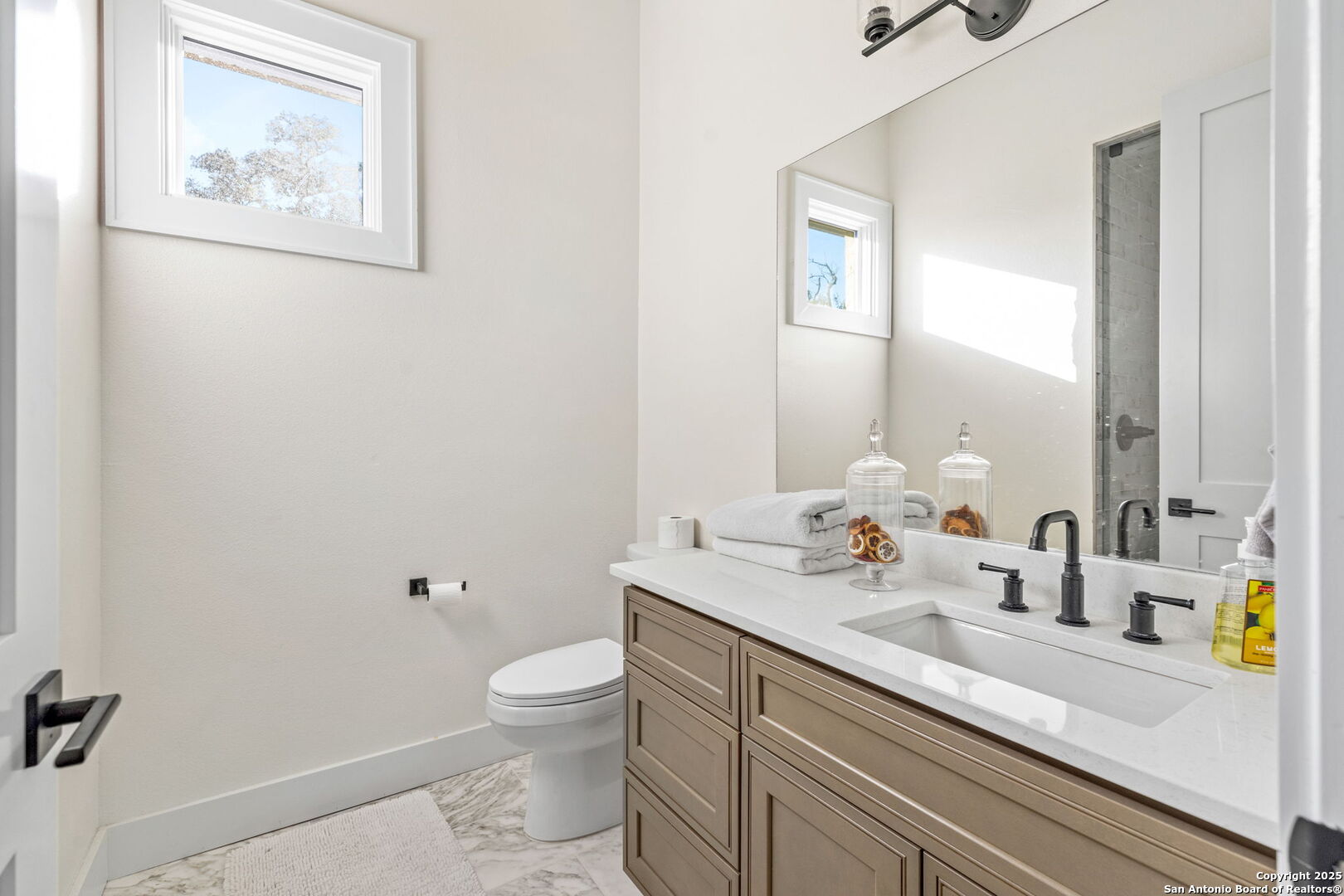 1146 Sisterdale Road Boerne, TX 78006 - Photo 19 of 94 a bathroom with a granite countertop sink mirror vanity and toilet