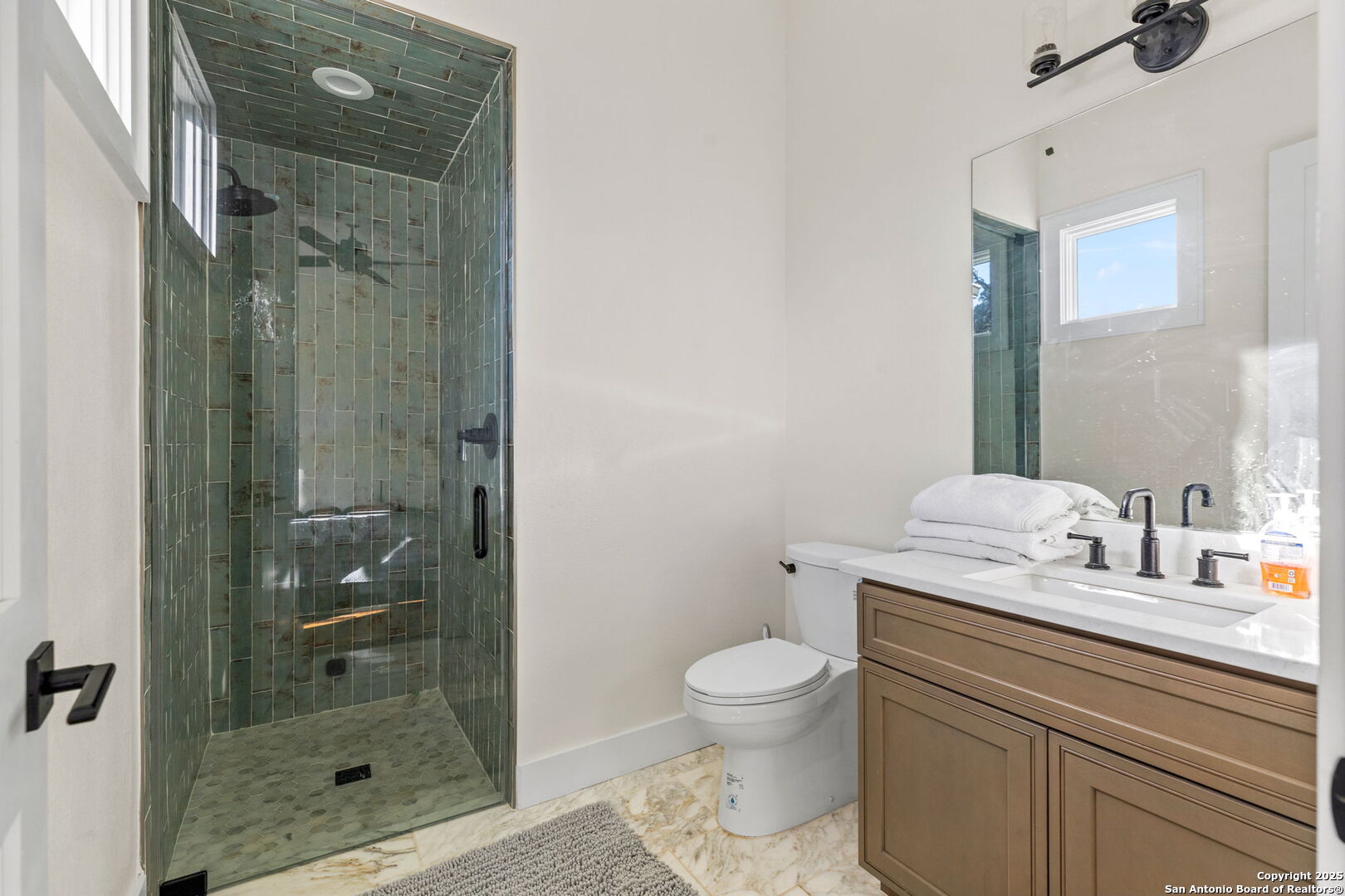 1146 Sisterdale Road Boerne, TX 78006 - Photo 20 of 94 a bathroom with a granite countertop sink a toilet and shower