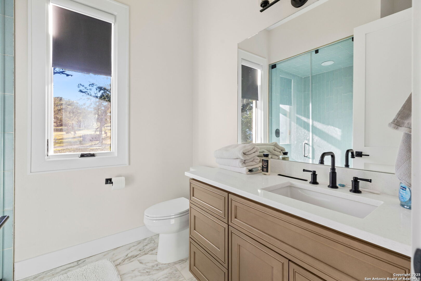 1146 Sisterdale Road Boerne, TX 78006 - Photo 22 of 94 a bathroom with a sink a toilet and a mirror