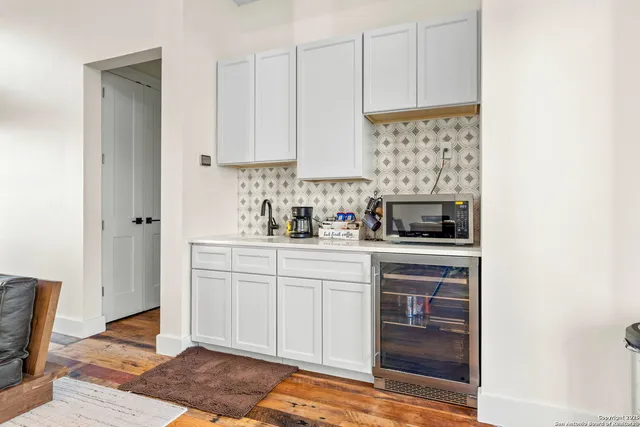 a backyard of a house with table and chairs under an umbrella