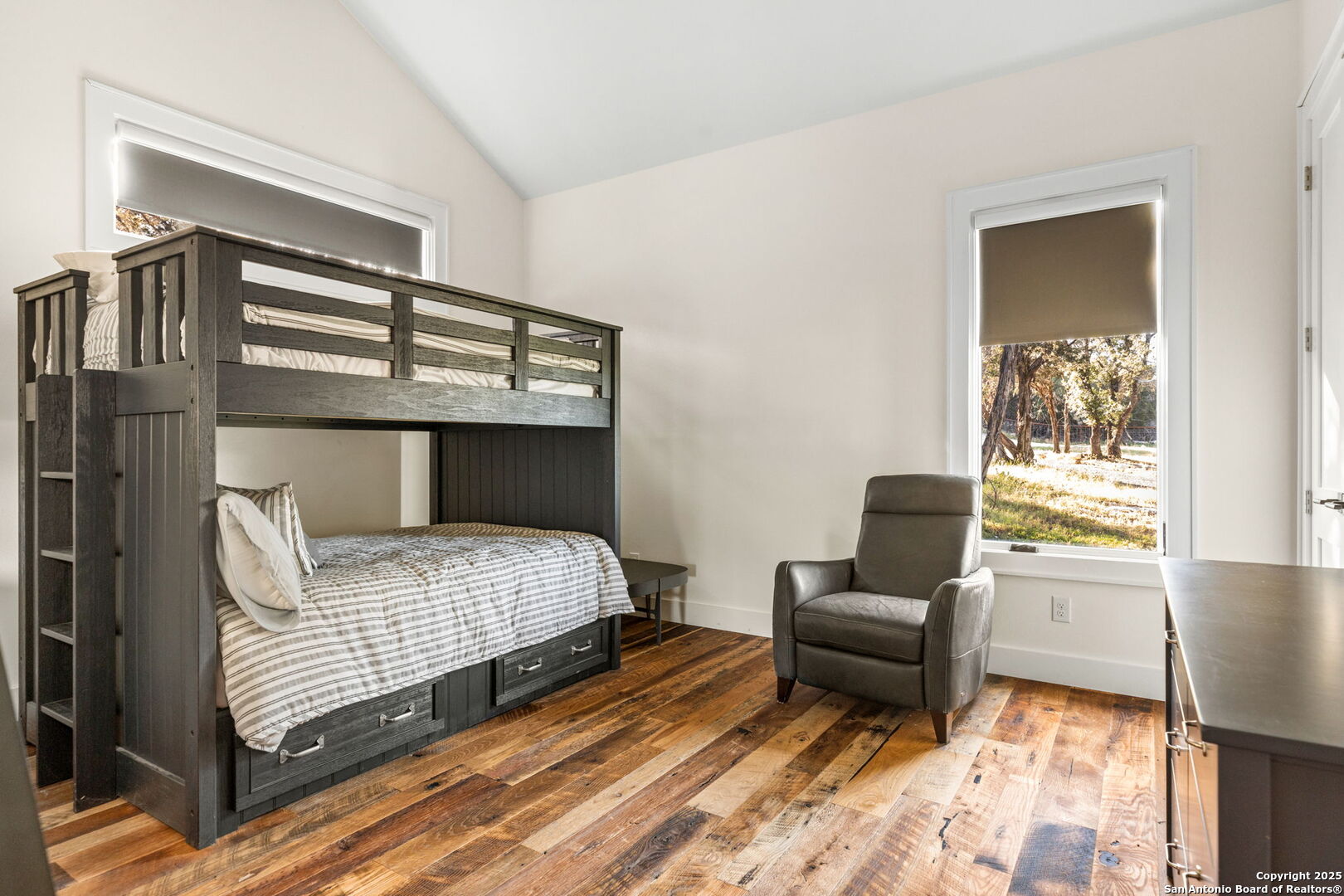 1146 Sisterdale Road Boerne, TX 78006 - Photo 36 of 94 a bedroom with a bed and wooden floor