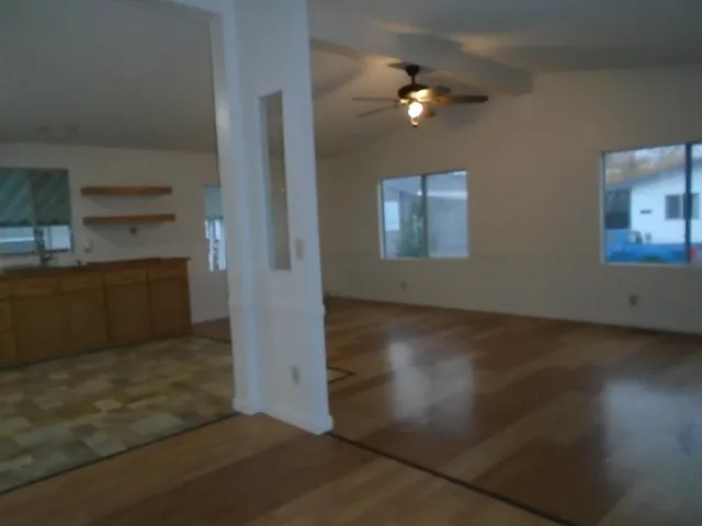 wooden floor in an empty room with a kitchen