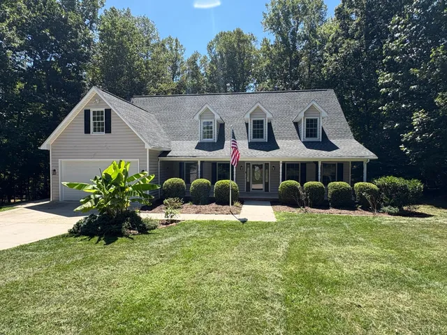 a view of a house with a yard and sitting area