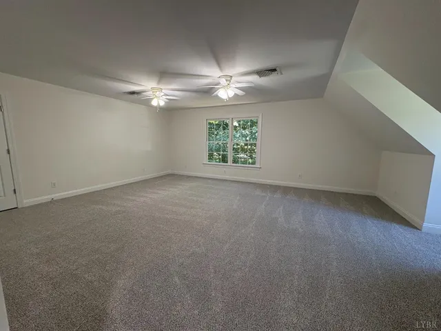 a view of empty room with wooden floor and window