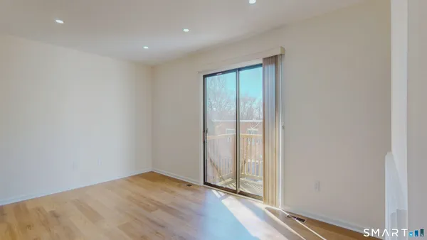 a view of an empty room with wooden floor