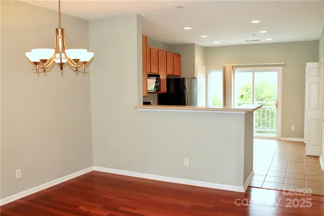 a view of a room with wooden floor and a ceiling fan