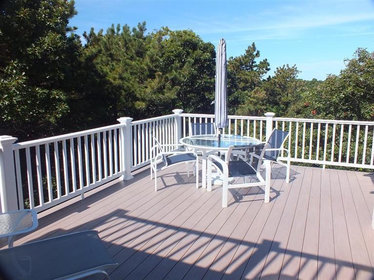 116 Castle Road Truro, MA 02666 - Photo 20 of 27 a view of a deck with table and chairs and wooden floor