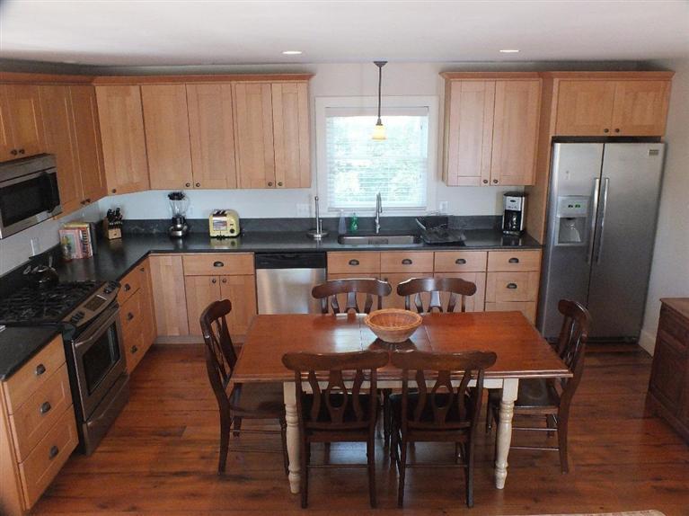 116 Castle Road Truro, MA 02666 - Photo 10 of 27 a kitchen with stainless steel appliances granite countertop a dining table chairs refrigerator and sink