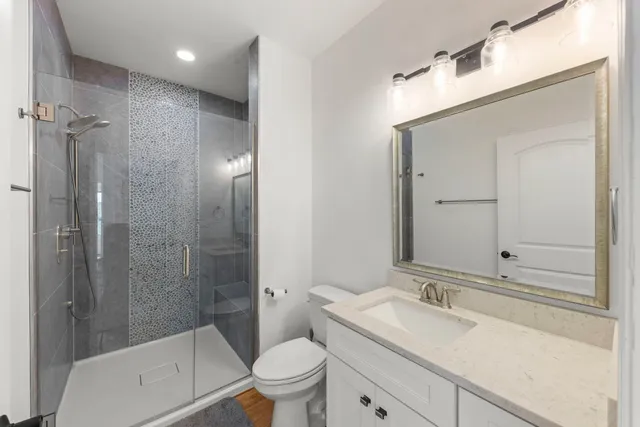 a bathroom with a sink a toilet and shower