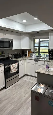 a kitchen with stainless steel appliances kitchen island granite countertop a sink and a stove