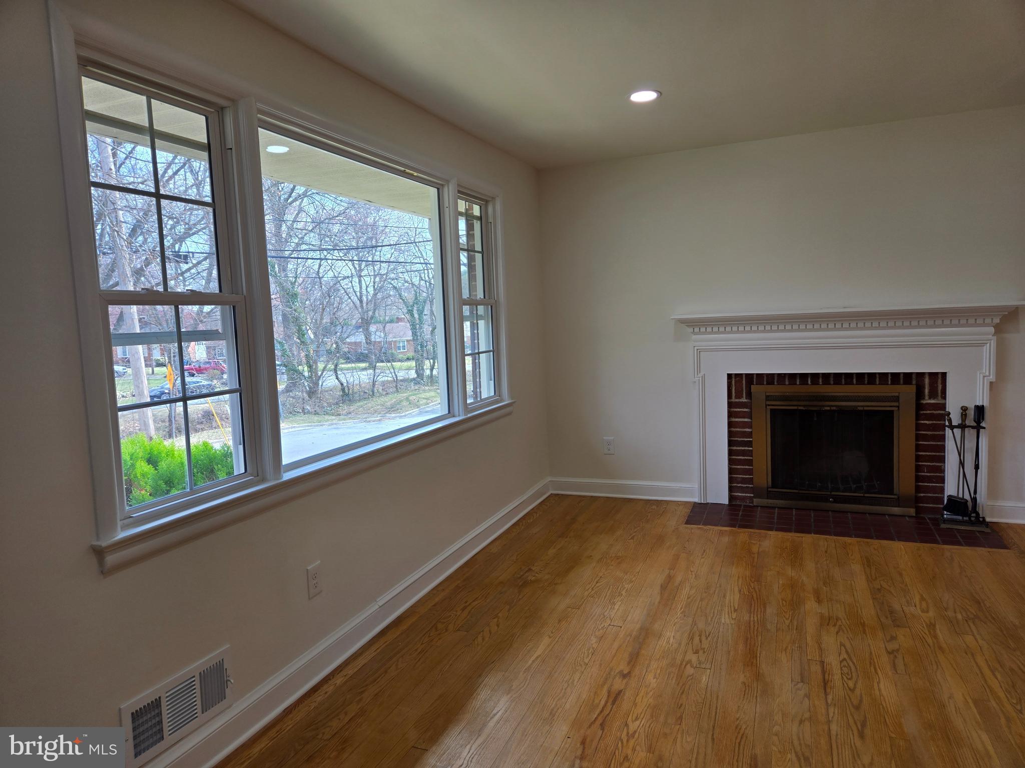 10500 Glenhaven Drive Silver Spring, MD 20902 - Photo 6 of 21 a view of empty room with wooden floor and a fireplace