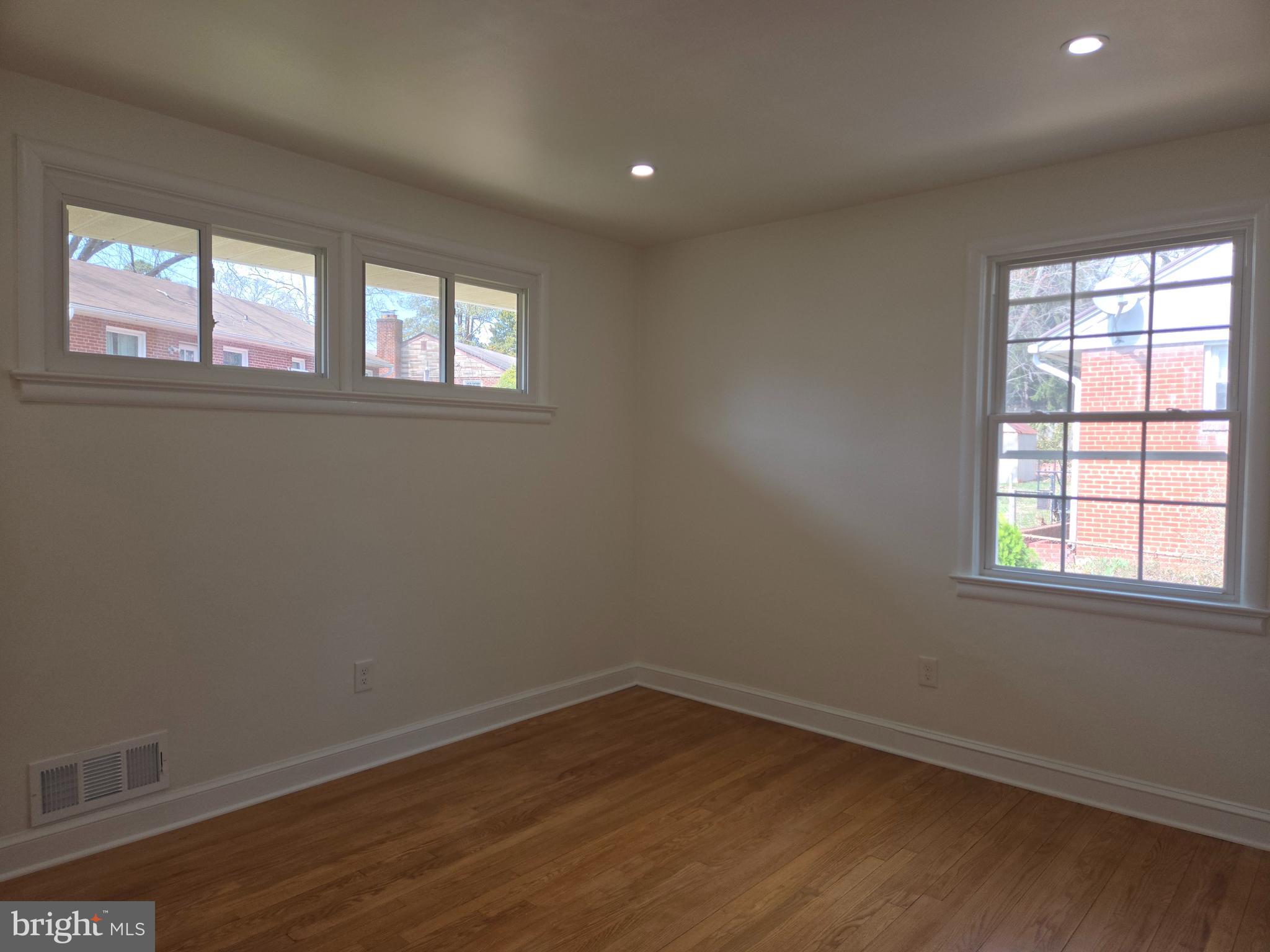10500 Glenhaven Drive Silver Spring, MD 20902 - Photo 8 of 21 an empty room with wooden floor and windows