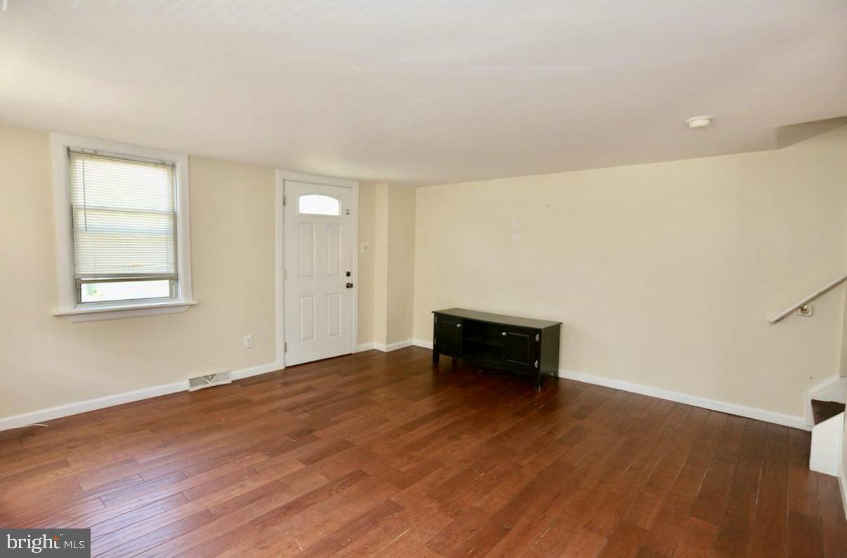 310 Ellis Street Glassboro, NJ 08028 - Photo 12 of 15 an empty room with wooden floor and natural light