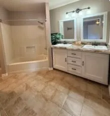 a bathroom with a granite countertop sink a mirror and a bathtub
