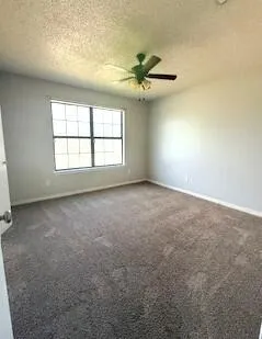 an empty room with windows and fan