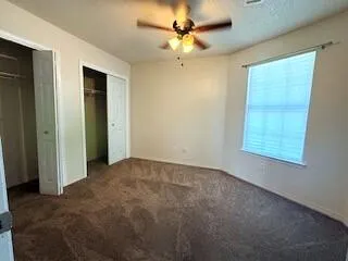an empty room with fan and windows