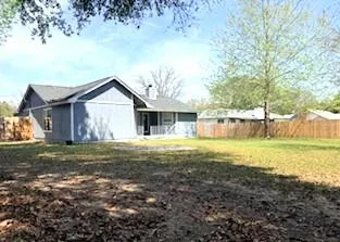 a view of backyard with tub and wooden fence