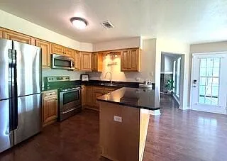 a kitchen with granite countertop stainless steel appliances and wooden cabinets