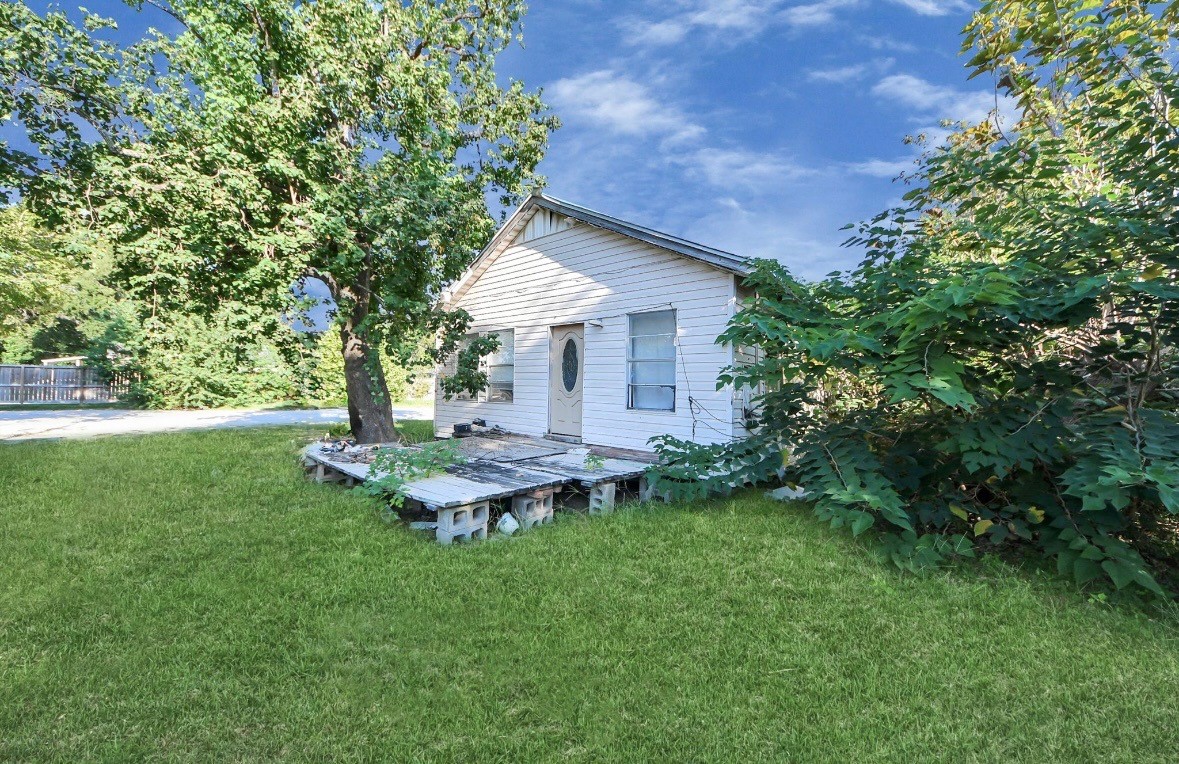 a view of a house with a backyard and a tree
