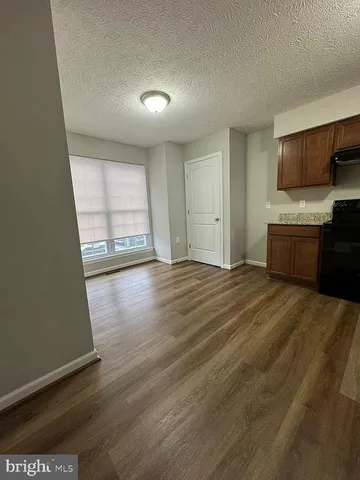 a view of a kitchen with wooden floor and electronic appliances