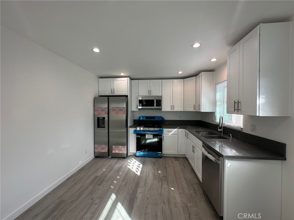 7012 Bertrand Avenue Reseda, CA 91335 - Photo 3 of 23 a kitchen with granite countertop a refrigerator stove top oven and sink