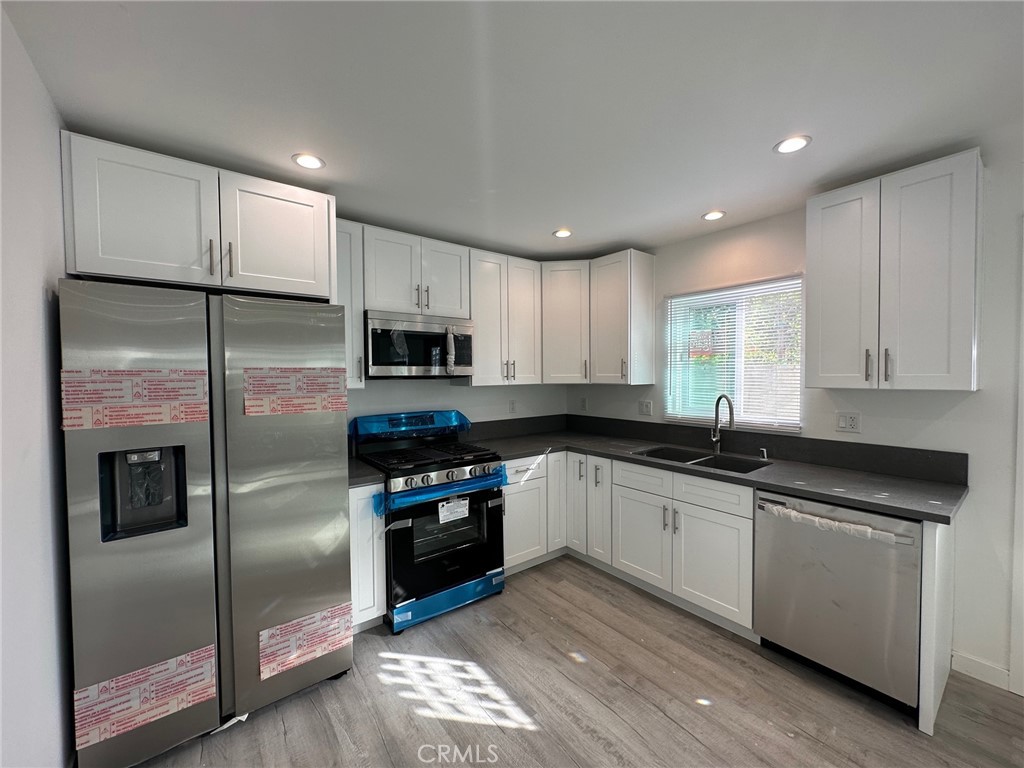7012 Bertrand Avenue Reseda, CA 91335 - Photo 4 of 23 a kitchen with stainless steel appliances granite countertop a refrigerator a sink a stove a microwave and island