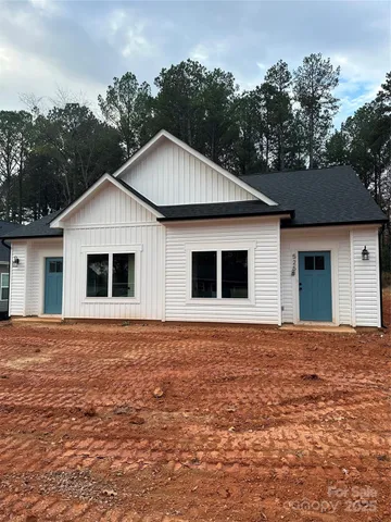 a kitchen with stainless steel appliances granite countertop a sink a refrigerator a stove a microwave and white cabinets with wooden floor