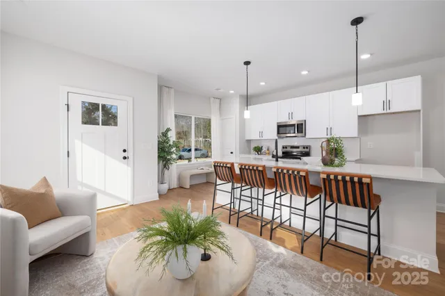 a living room with furniture kitchen and a wooden floor