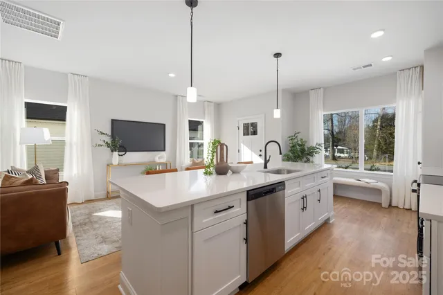 a large kitchen with kitchen island a sink appliances and a counter top space