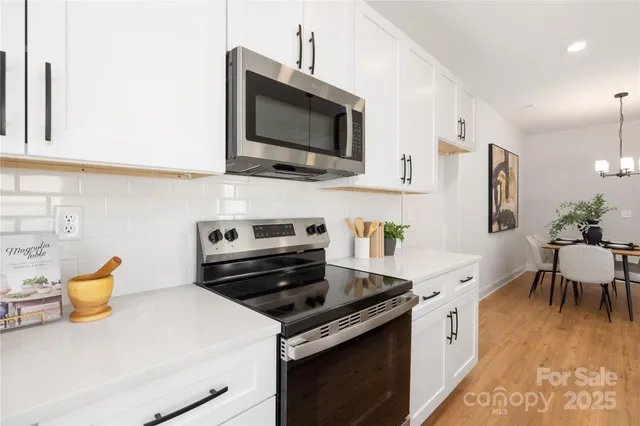 a kitchen with stainless steel appliances a stove a sink and a microwave