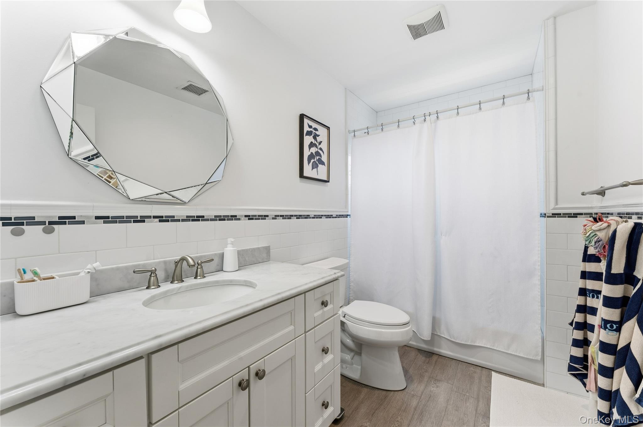 3483 Frederick Street Oceanside, NY 11572 - Photo 14 of 34 a bathroom with a granite countertop sink mirror vanity and toilet