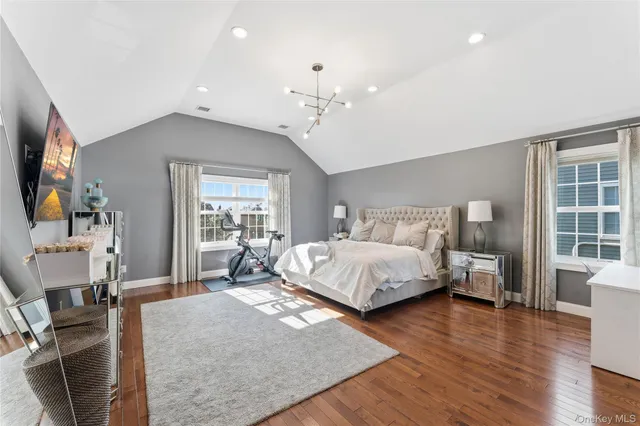 a bedroom with a large bed and wooden floor