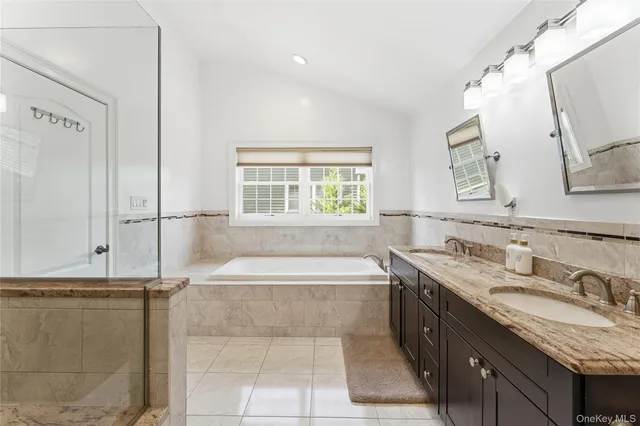 a spacious bathroom with a granite countertop tub sink and mirror