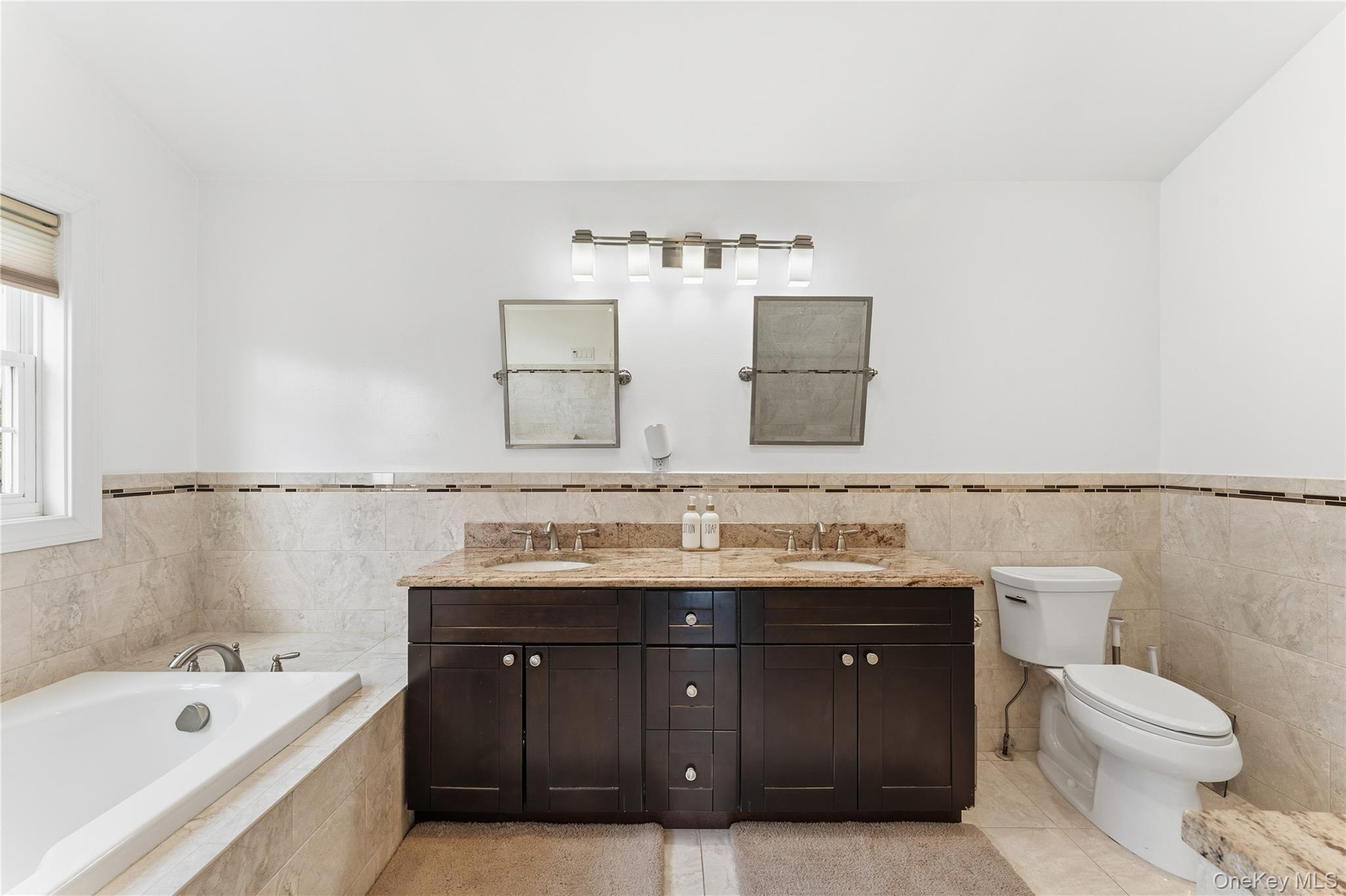 3483 Frederick Street Oceanside, NY 11572 - Photo 20 of 34 a bathroom with a granite countertop bathtub sink vanity mirror and toilet