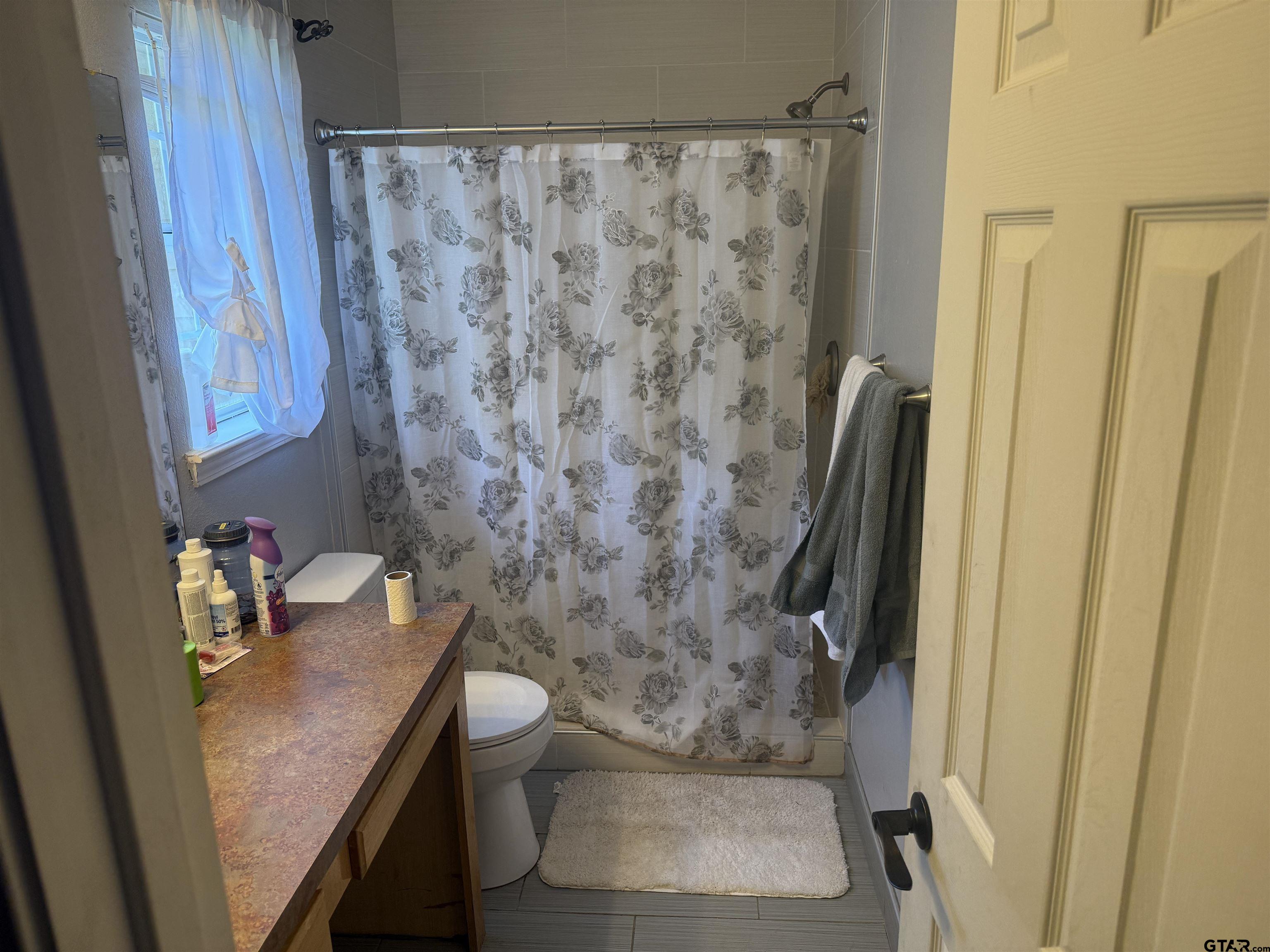 111 Jerome Court Rusk, TX 75785 - Photo 12 of 16 a bathroom with a granite countertop sink a toilet and a shower