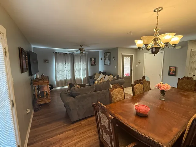 a living room with furniture dining table and a chandelier