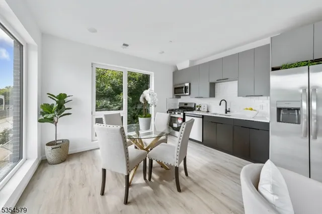 a kitchen with a table chairs refrigerator and microwave