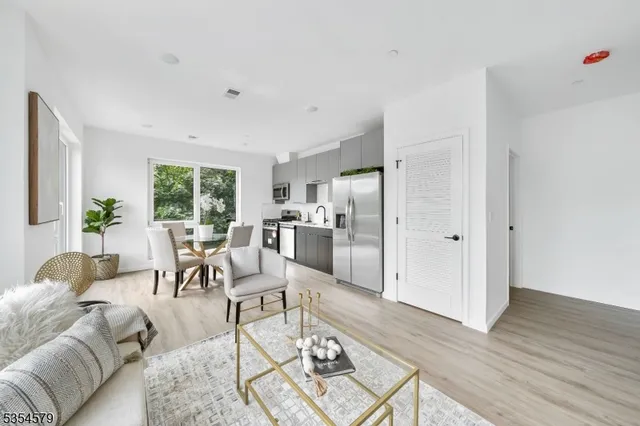 a living room with furniture wooden floor and a large window