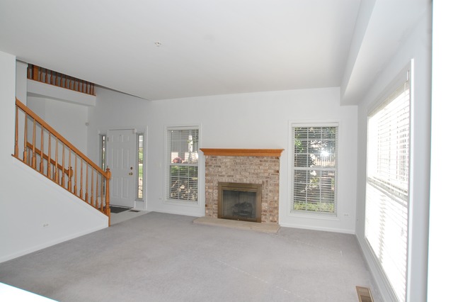 2103 Ivy Ridge Drive Hoffman Estates, IL 60192 - Photo 5 of 24 a view of empty room with fireplace and stairs