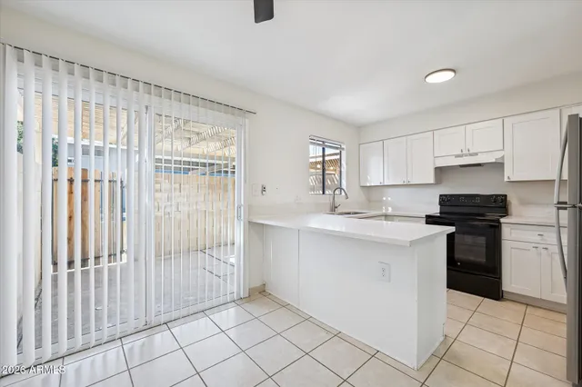 an empty room with a ceiling fan and window