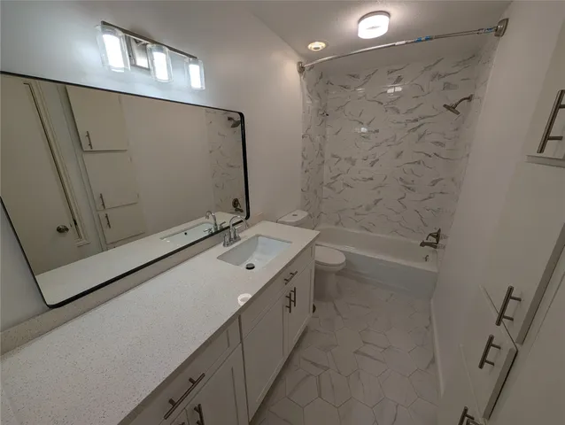 a bathroom with a double vanity sink a toilet and shower