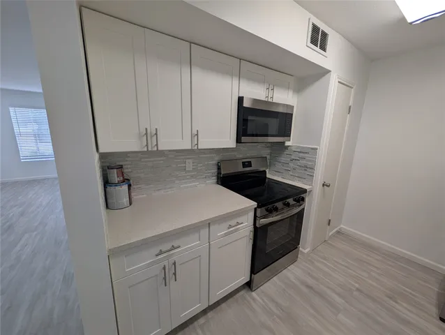 a kitchen with a sink and a stove top oven